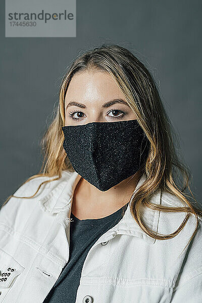 Junge Frau mit schützender Gesichtsmaske während COVID-19