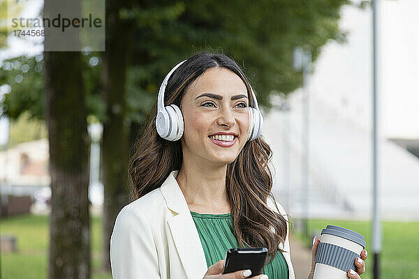Glückliche Frau  die Musik über kabellose Kopfhörer hört