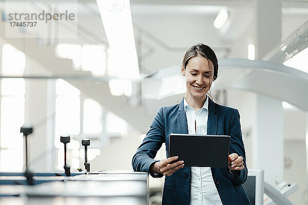 Weibliche Geschäftsfachfrau nutzt digitales Tablet in der Industrie