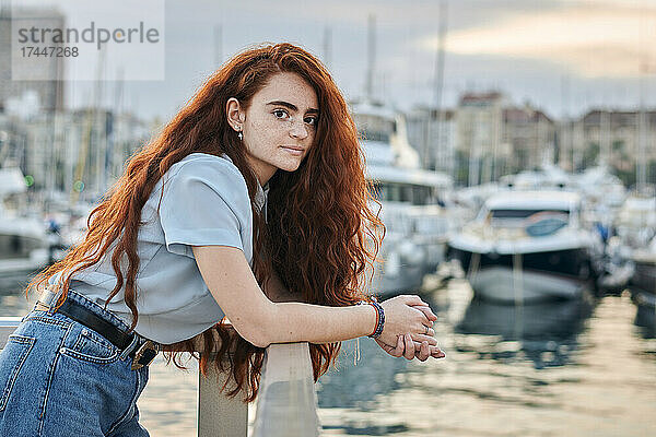 Porträt einer jungen rothaarigen Frau in einem Seehafen einer Stadt