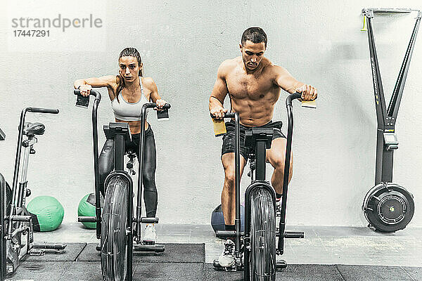Paar macht Fahrradfahren im Fitnessstudio  Crossfit
