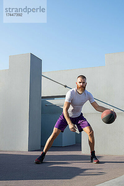 Athletischer Spieler dribbelt Basketballball