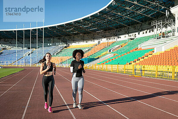 Diverse Sportlerinnen joggen im Stadion