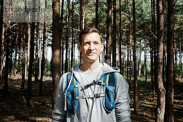 Porträt eines Mannes  der in einem Wald stand und eine Laufweste trug