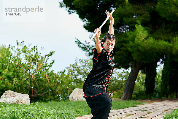 Frau übt Kung-Fu mit einem Stock