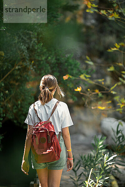 Touristin mit Rucksack reist durch den Wald