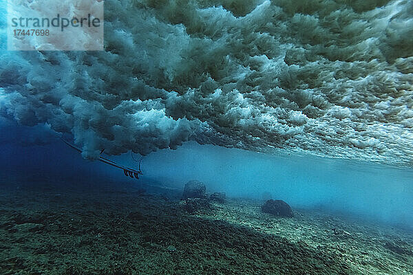 Unter Wasser Blick auf die Welle  Surfer sitzt auf Surfbrett  Unterwasseraufnahme