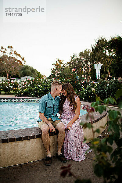 Mann und Frau posieren neben dem Brunnen im Rosengarten in San Diego