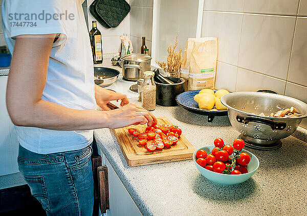Seitenansicht einer Frau in der Küche beim Zubereiten des Abendessens mit Gemüse