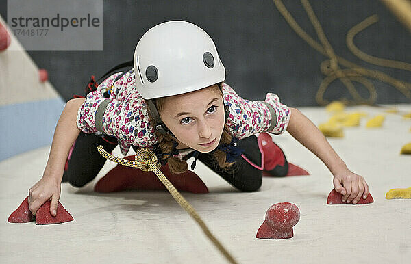 Mädchen klettert an der Indoor-Kletterwand in London