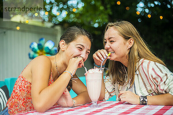 Hinterhofporträt von Freunden  die zusammen lachen und trinken