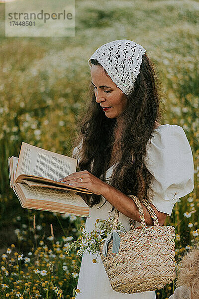 Eine Frau in einem Schal und einem Kleid  die ein Buch liest