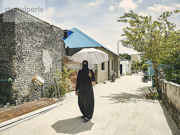 Frau auf der Straße auf der Insel Huraa  Malediven