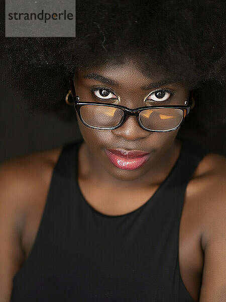 Schöne junge schwarze Frau mit Afro-Haaren und Brille