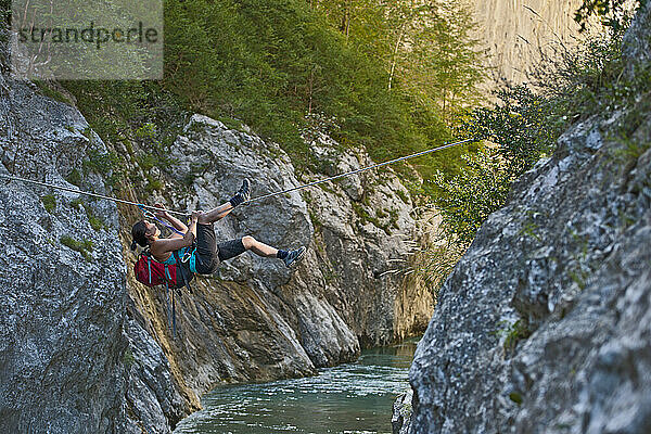 Frau überquert Fluss auf Tiroler Traverse in der Verdon-Schlucht