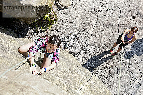 Teenager-Mädchen klettert am Harrisons Rock in der Nähe von Tunbridge Wells