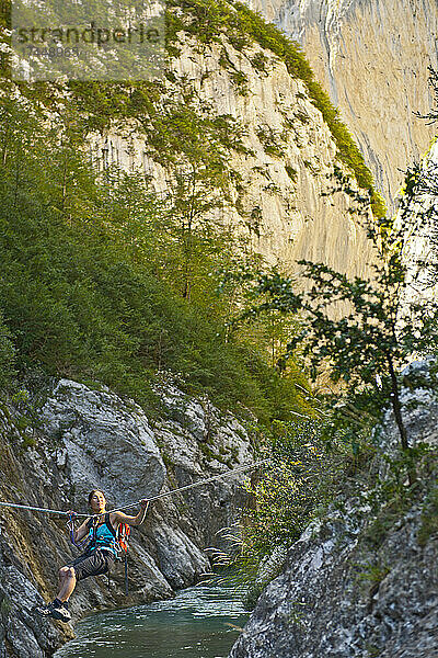 Frau überquert Fluss auf Tiroler Traverse in der Verdon-Schlucht