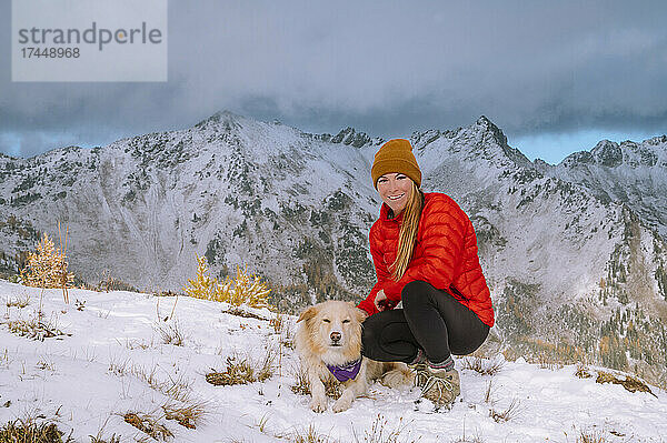 Wanderin und Hund auf einem verschneiten Bergrücken in den Kaskaden