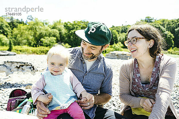 Nahaufnahmeporträt einer dreiköpfigen Familie  die am Strand lacht