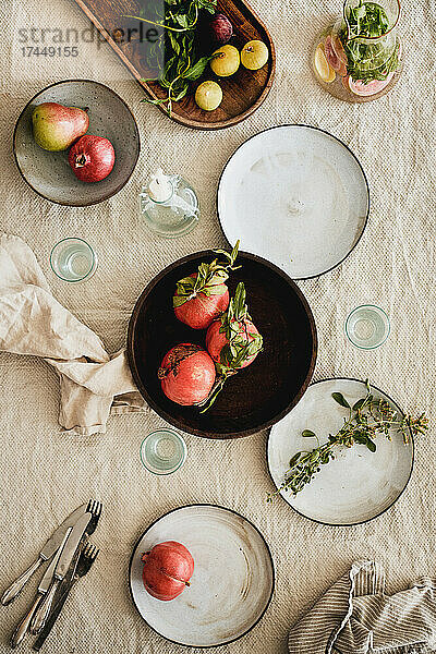 Gedeckter Tisch mit Geschirr und Gläsern über einer Leinentischdecke
