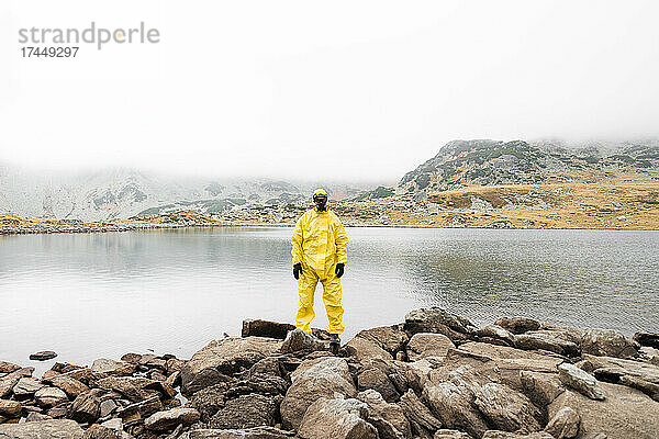 Person  die während der Covid-19-Pandemie einen gelben Schutzanzug trägt