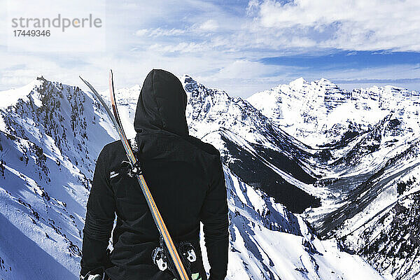 Extremski-Konzeptperson mit Skiern in der verschneiten Bergwildnis