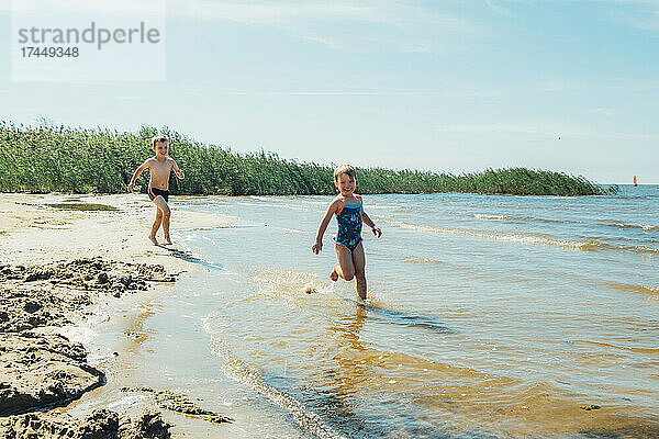 Kinder spielen am See. Konzept einer freundlichen Familie.