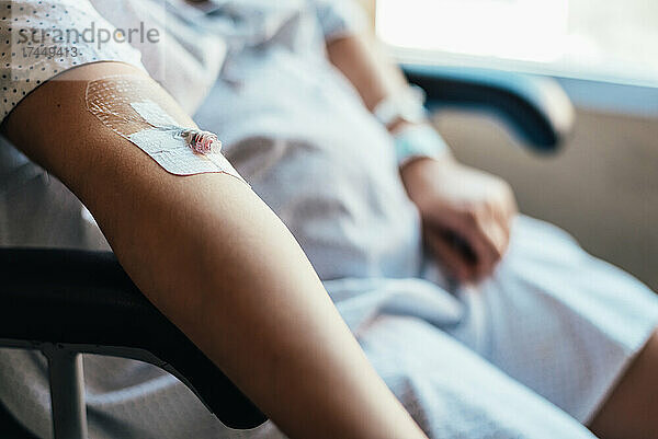 Nahaufnahme einer intravenösen Leitung im Arm eines Patienten.