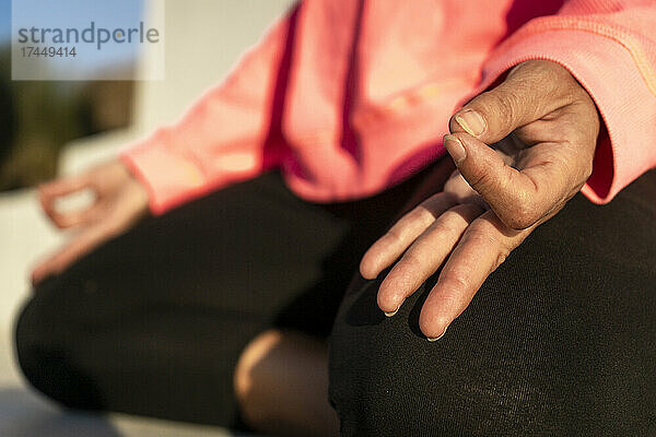 Nahaufnahme der Hände einer Frau  die an einem ruhigen Ort meditiert
