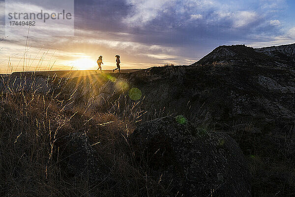 Silhouette von zwei Trailrunnern in Badlands