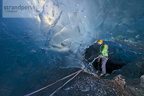 Frau erkundet Eishöhle am Svinafellsjökull-Gletscher