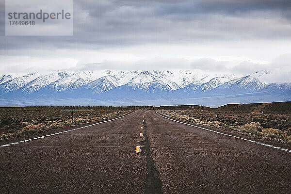 Leere  einsame  einsame Wüstenstraße mit Bergen in der Ferne  Nevada