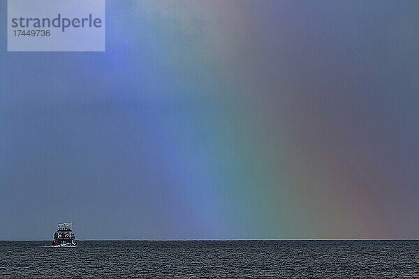 Fischerboot unter Regenbogen im Indischen Ozean
