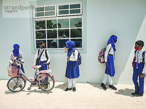 Asiatische Kinder in Schuluniform tragen Schutzmaske