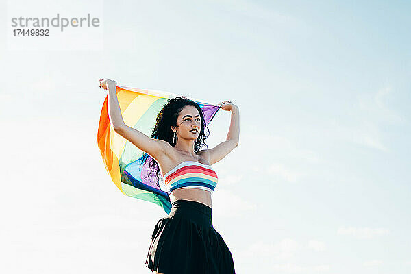 Junge Frau hält LGBT-Regenbogenfahne