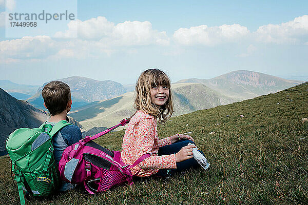Lächelndes Mädchen auf dem Gipfel eines Berges auf einer Wanderung in Wales