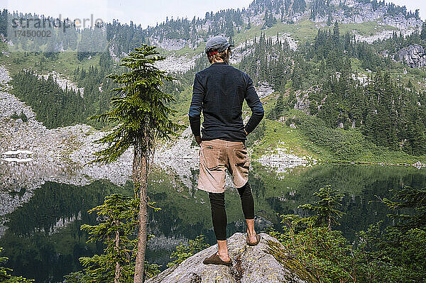Wanderer blickt beim Rucksackwandern auf einen Alpensee