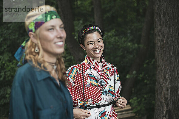 Frauen gemischter Abstammung in böhmischer Mode im Wald  die zusammen lächeln