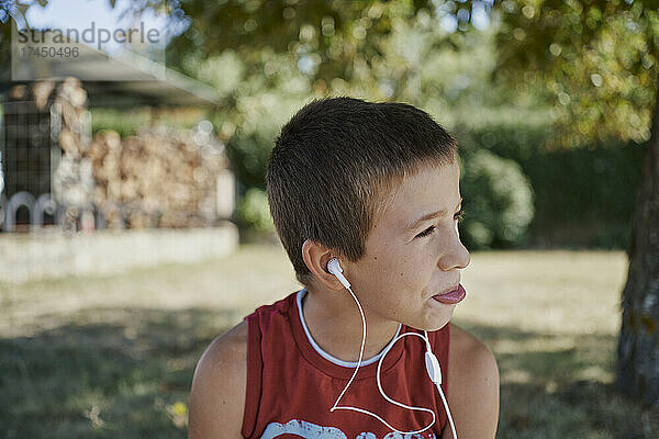 Ein süßer Junge hört Musik  während er wegschaut