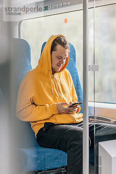 Glücklicher junger Mann  Teenager  schreibt SMS im Telefon  Smartphone.