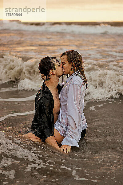Junges Paar küsst sich im Meer