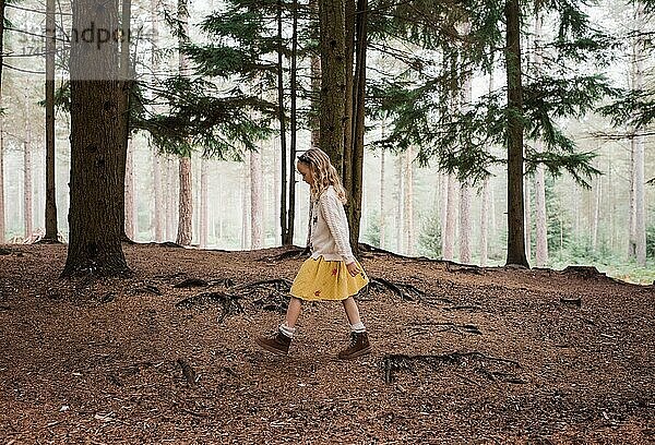 Mädchen geht im Herbst allein durch einen Wald