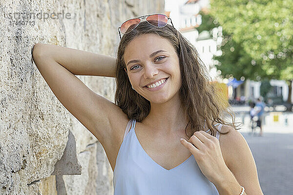 Porträt einer jungen Frau  die in der Stadt in die Kamera lächelt