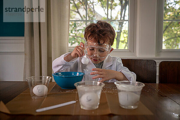 Junge Wissenschaftlerin konzentriert sich im Laborkittel auf ein Experiment