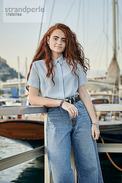 Porträt einer jungen rothaarigen Frau in einem Seehafen einer Stadt