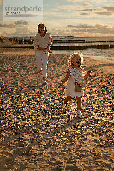 Mutter und Tochter spielen am Strand.