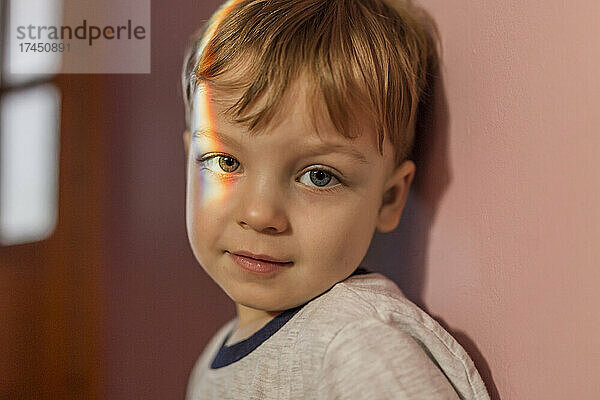 Porträt eines kleinen Jungen mit Regenbogenlicht auf seinem rechten Auge
