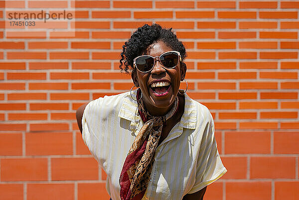 Trendy black female laughing on street