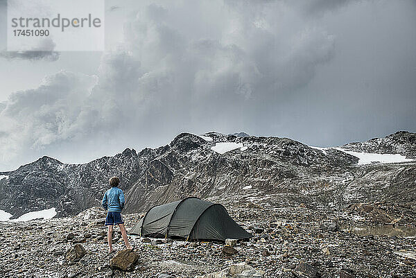Ein Junge schaut nach einem Sturm im Glacier Peak Wilderness-Gebiet über ein Zelt.