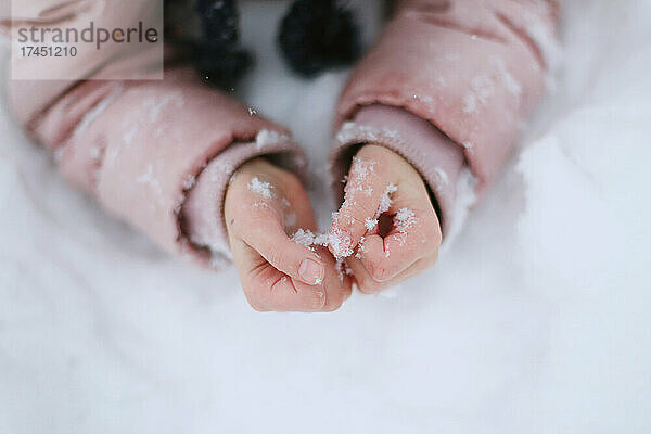 Kinderhände im Schnee  Nahaufnahme.